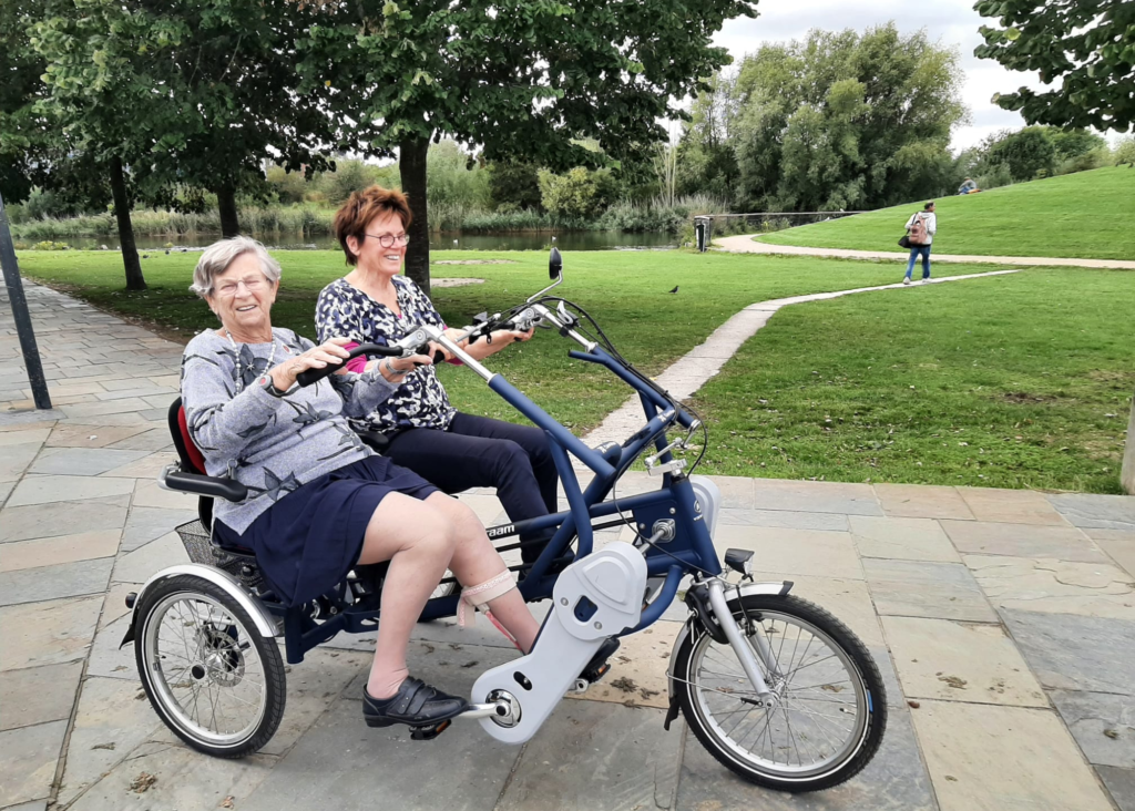 Twee vrouwen fietsen samen op een duofiets in het Griftpark.