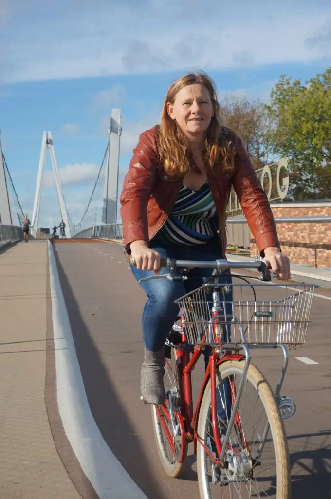 Christien fietsend over brug