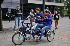 Wethouder van mobiliteit Lot van Hooijdonk, en Fietsmaatjes Utrecht voorzitter Jelle Bakker rijden de duofiets over het testparcours.