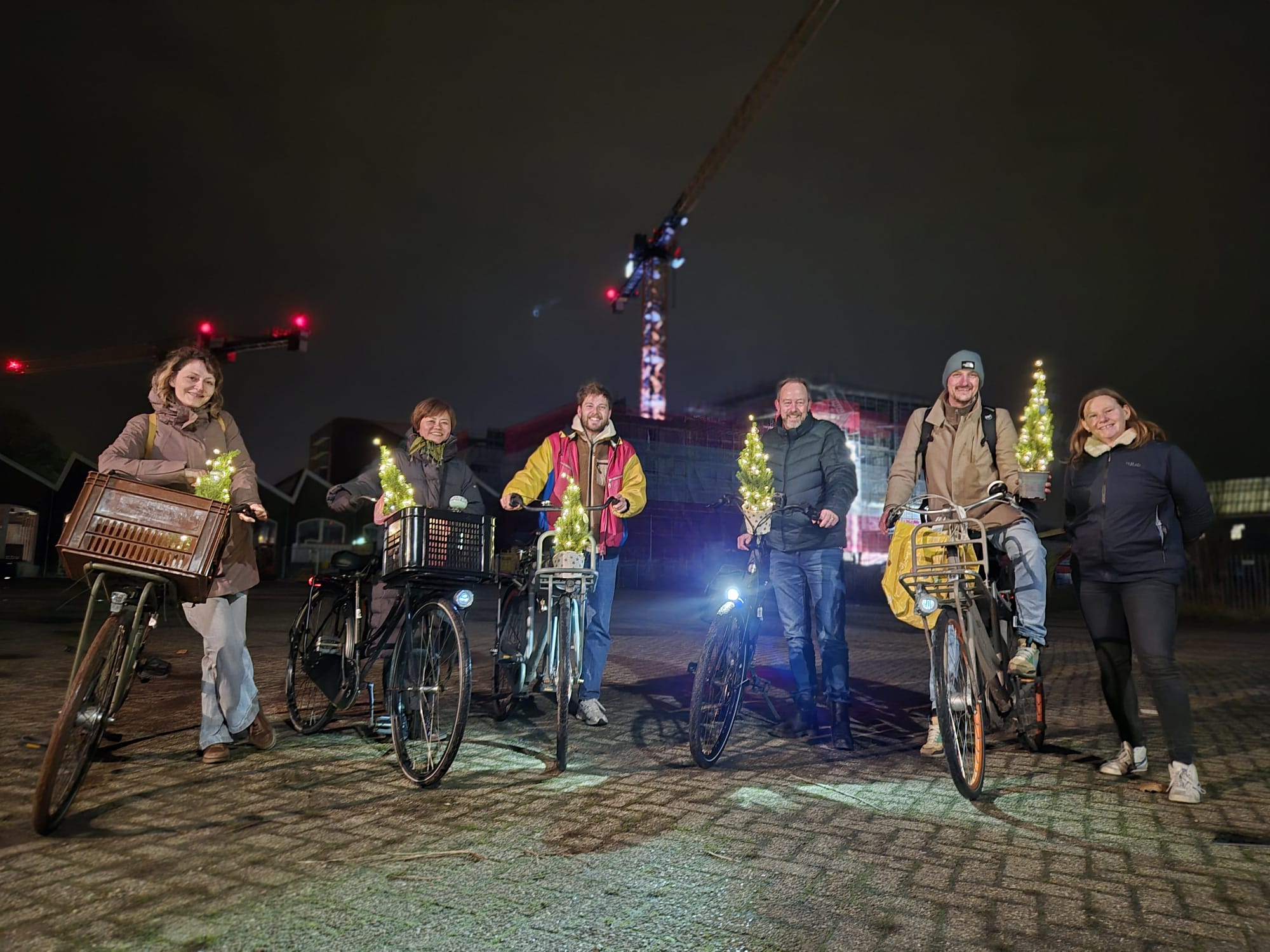 Het kernteam van Fietsmaatjes Utrecht met fietsen en kerstverlichting op straat